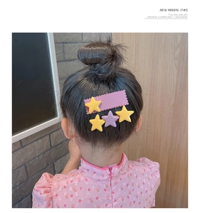 Gros plan de jolies pinces à cheveux étoiles violettes et jaunes sur une fille