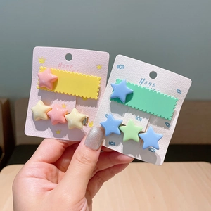 Gros plan de pinces à cheveux étoiles colorées pour filles sur carte de présentation