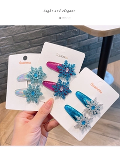 Detail of snowflake hair clips with shiny sequins and colorful gemstones on card