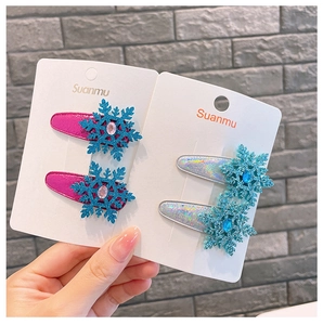 Close-up of glittery snowflake hair clips with rhinestones on a white display card