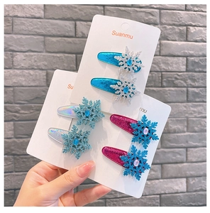 Close-up of snowflake hair clips with shimmering sequins and crystal stones on white card
