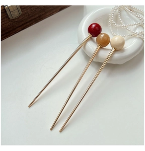 Detailed view of three French-style gold hair sticks with coffee and cream glass beads