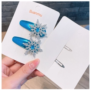 Detail of blue faux leather hair clips with silver snowflake and blue gemstone accents
