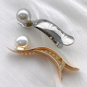 Ensemble élégant de barrettes à perles dorées et argentées sur fond de soie blanche