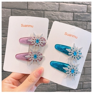 Detailed view of pink and blue snowflake hair clips with shiny PU leather and blue gemstones