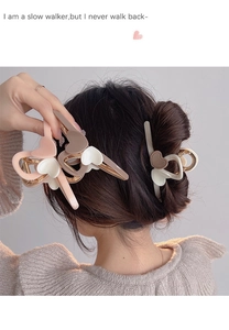 Macro shot of large heart-shaped acrylic hair claw clip in elegant milk tea colors