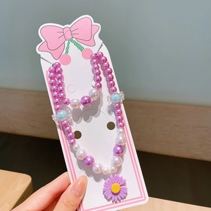 Detailansicht der Kinderperlen-Schmuckset mit Gänseblümchen-Anhänger auf Displaykarte