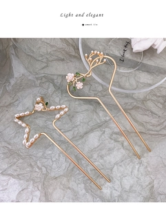 Detailopname van gouden haarspelden met hart, bloemen en parels voor dameskapsels