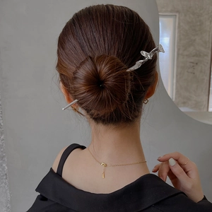 Détail d'un pic à cheveux en métal argenté torsadé pour chignon moderne minimaliste