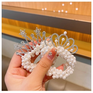 Close-up of pearl hair ties featuring rhinestone crown and star silver metal charms