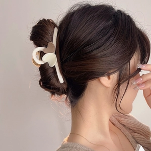 Elegant large milk tea colored heart hair claw clip shown worn on a model's head