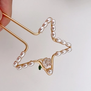 Elegante gouden haarspeld met parelster en delicate roze bloemornament versiering