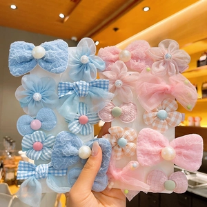 Détail de barrettes à fleurs en dentelle rose avec perles pour petites filles