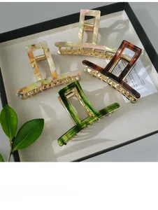 Close-up of four geometric acetate hair claws in tortoise shell and marble colors