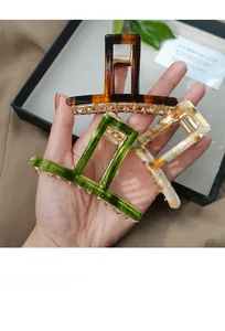 Detailed view of three geometric acetate hair claws in tortoiseshell and emerald colors