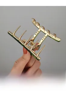 Close-up of durable gold metal hair claw clip with dark green base for hair styling