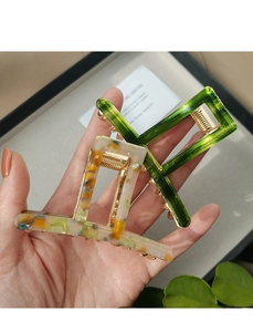 Detail of emerald green and marble acetate hair claws with metal spring closure