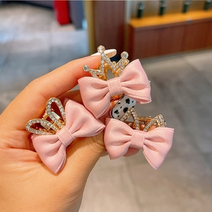 Detailaufnahme der rosa Satin-Haarschleifen mit goldenen Strass-Kronen für Mädchen