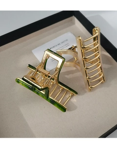 Detail of French acetate hair clips in green and white marble with gold metal finish