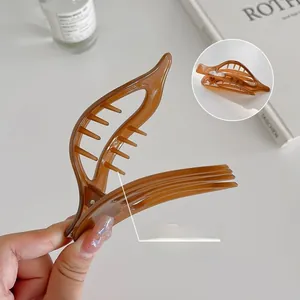 Détail d'une pince à cheveux feuille marron translucide avec dents lisses et élégantes