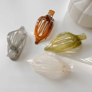 Vue détaillée des pinces à cheveux en résine creuse en gris, ambre, vert et blanc crème
