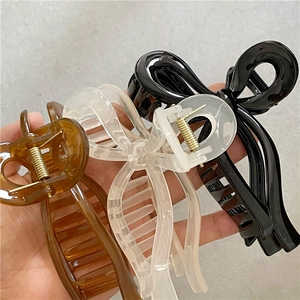 Three elegant bow hair claws in amber brown, clear white, and sleek black colors