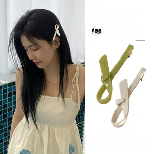 Detail of avocado green and cream beige bow hair clips for bangs and fringe styling