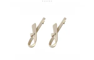 Detail view of 8cm cream-colored acetate hair clips featuring a stylish knot design