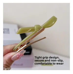 Detail of green bow acetate hair clip showing the secure grip anti-slip metal teeth