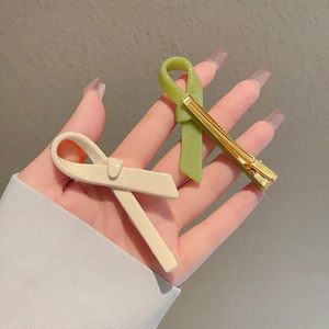 Elegant cream and avocado green acetate bow hair clips with gold metal duckbill grip