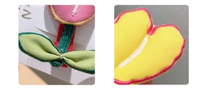 Close-up of handmade embroidered fabric tulip hair clip with detailed stitching and textures