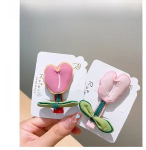 Detailed embroidery on tulip fabric hair clips in vibrant pink and green tones