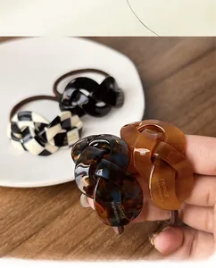 Detailed view of high-elastic acetate checkerboard and tortoiseshell twist scrunchies