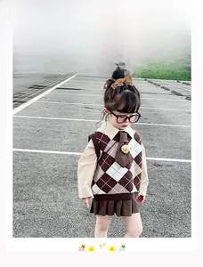 Dettaglio outfit stile collegiale per bambina con gilet a rombi e gonna a pieghe