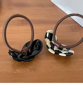 Detail view of high-elasticity hair ties with black and checkerboard acrylic chain links
