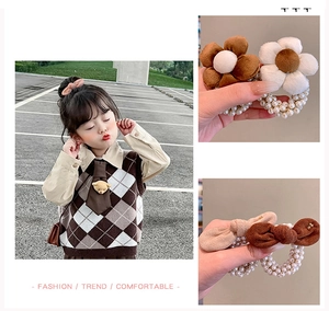 Dettaglio di fiocchi in peluche floreali e elastici con perle per bambine