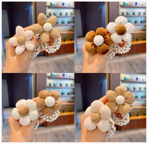 Dettaglio di elastici per capelli con fiori in velluto e perle finte per bambine
