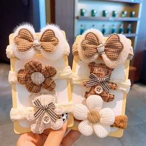 Detailansicht der Kinder-Haarbänder mit Plüschbären, Blumen und Schleifen in Creme und Braun
