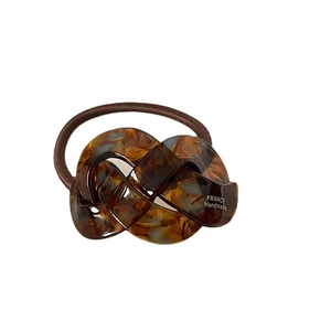 Elegant tortoiseshell acetate twist hair tie with amber checkerboard pattern and elastic band