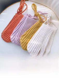 Close-up of winter knitted gloves with string in orange, purple, yellow and white colors