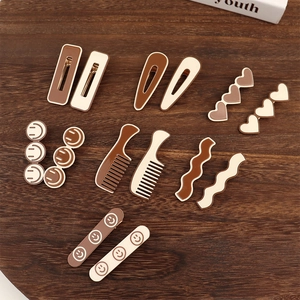 Detailed set of matte milk tea brown hair clips in various shapes on dark wood
