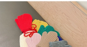 Close-up of colorful knitted winter mittens for kids with anti-lost neck string feature
