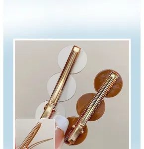 Detail showing the metal alligator clip back and glossy circular design on hairpins