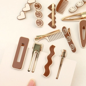 Detail view of milk tea brown hair clips with heart and smiley face designs on card