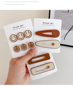 Detailed view of three vintage brown and cream hair clips on a Cream Girl display card