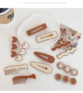 Close-up of caramel and cream hair clips with heart and smiley patterns on a tray