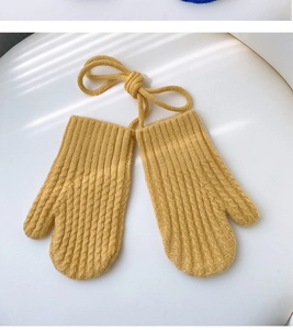 Detail of yellow knitted mittens with corn texture and anti-lost neck strap for kids
