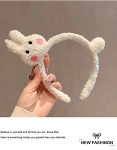 Dettaglio di un cerchietto per gatti in morbido peluche bianco con pile riccio e decorazioni