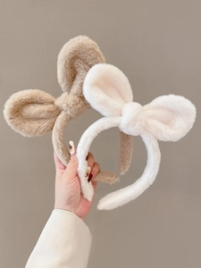 Detailopname van zachte pluche konijnenoor haarbanden in beige en crèmewit