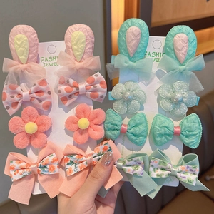 Dettaglio di fermagli per capelli per bambine con fiori e orecchie di coniglio rosa e verdi